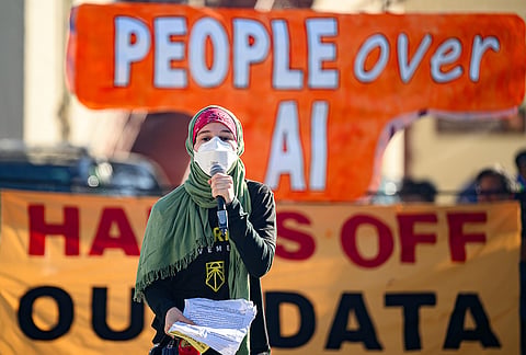 A protester speaks into a microphone outside the OpenAI DevDay 2026 conference in San Francisco, California Tuesday, Sept. 29, 2026. 
