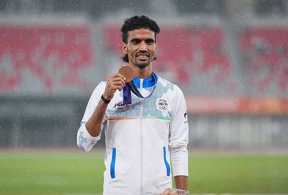 Bronze medalist Gulveer Singh of India poses on the podium following the men's 5000-meter final at the Asian Games in Nagoya, Japan, Tuesday, Sept. 29, 2026. 
 - | Photo: AP/Lee Jin-man