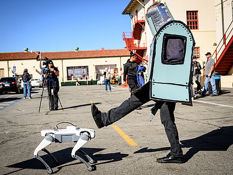 An AI protester raises their foot against a robot dog outside the OpenAI DevDay 2026 conference in San Francisco, California on Tuesday, September 29, 2026. 