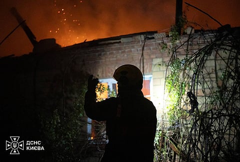 A rescuer works on the site of a residential house damaged after a Russian drone strike on Kyiv, Ukraine. 
