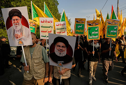 Iraqi carry portraits of slain former Iranian Supreme Leader Ayatollah Ali Khamenei, left, and slain Hezbollah leader Hassan Nasrallah during celebrations marking the complete withdrawal of U.S. troops from Iraq, in Baghdad, Iraq, Wednesday, Sept. 30, 2026. 