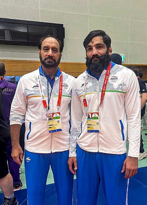 India's Greco Roman wrestler Sunil Kumar with head coach Hargobind Singh after winning bronze medal in men's 87kg at Asian Games. 