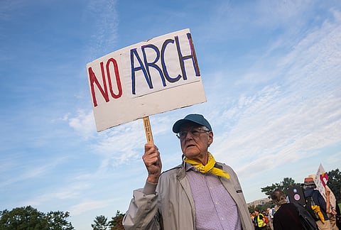 A demonstrator holds a sign at Memorial Circle to protest the proposed Triumphal Arch, Thursday, Oct. 1, 2026, in Arlington, Virginia.
