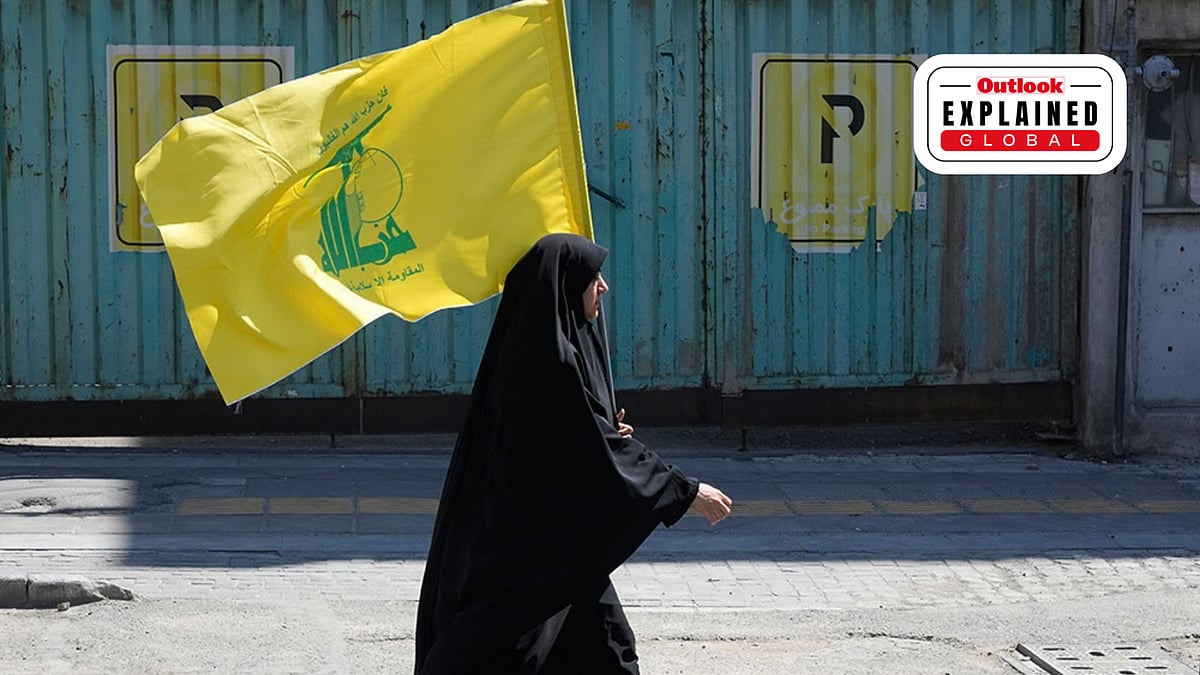 A woman carries a flag of Lebanon's militant Hezbollah group  -  | Photo: AP/Vahid Salemi