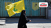 As The Middle East’s Balance Shifts, Syria And Hezbollah Test A New Relationship | Photo: AP/Vahid Salemi : A woman carries a flag of Lebanon's militant Hezbollah group