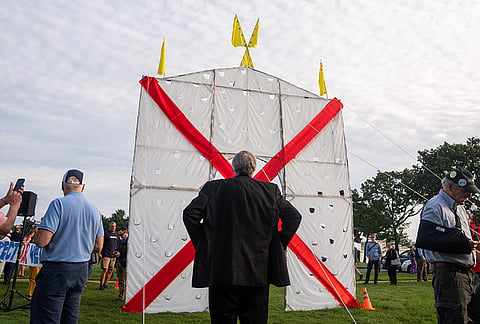 Sen. Jeff Merkley, D-Ore., watches as demonstrators lift an anti-arch structure at Memorial Circle to protest the proposed Triumphal Arch, Thursday, Oct. 1, 2026, in Arlington, Virginia.