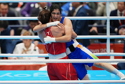 India's Parveen, in blue, hugs Taiwan's Chen Nien-chin, in red, after winning their women's 65kg boxing final match at the Asian Games in Nishio, Aichi prefecture, Japan, Friday, Oct. 2, 2026.  
