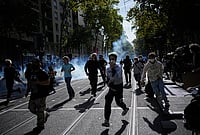 In Photos | France Protests: Fires, Tear Gas And Clashes As Students Take To Streets | Photo: AP/Laurent Cipriani : Students run out the teargas during a protest against under-resourced schools in Lyon, France, Friday, Oct. 2, 2026.