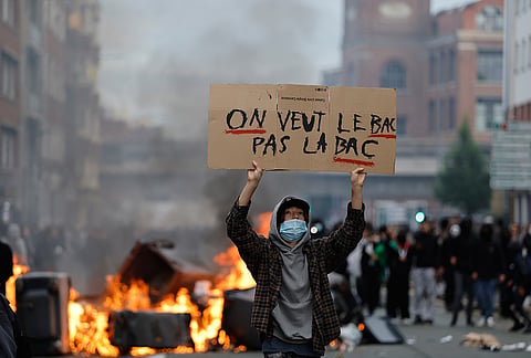 A students holds a board reading, "we want the BAC (High School Diploma) Not the BAC (Anti-criminality units)" during a protest to demand more resources at school, in Lille, France, Thursday, Oct. 1, 2026. 
