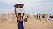 Yemen’s Western Front Burns As Hunger Surges And Thousands Flee | Photo: UNICEF/Mahmoud Alfilastini : A young girl carries relief supplies on her head at a camp for displaced people in Aden, Yemen.