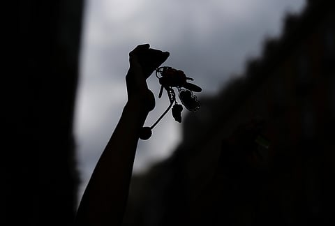 An activist holds up the keys to a flat near the Spanish Parliament during a protest following the eviction of 87-year-old Maria del Carmen Abascal to demand stronger laws to protect renters in Madrid, Spain, Friday, Oct. 2, 2026. 
