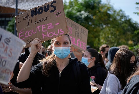A student hold a board reading "We are the future, listen to us! " during a protest against under-resourced schools in Lyon, France, Friday, Oct. 2, 2026.