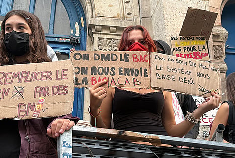 In this photo taken with a smartphone, high school students block the entrance of Voltaire high school to demand more resources, in Paris, Thursday, Oct. 1, 2026. 
