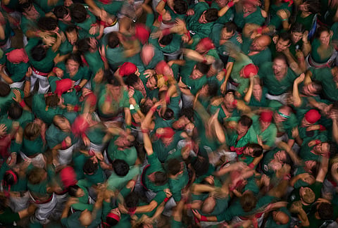 Members of Castellers de Sabadell react after completing a "castell" human tower during the 30th Concurs de Castells, or Human Tower Competition, in Tarragona, Spain, Saturday, Oct. 5, 2026. 
