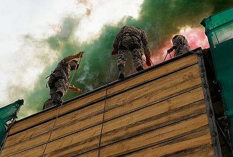 Iranian army members prepare to rappel down a wall during the opening ceremony of one of the military training centers for volunteers being set up throughout squares in downtown Tehran, Iran, Saturday, Oct. 3, 2026. 

