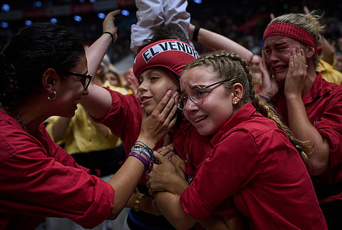 Members of Castellers Nens del Vendrell react after completing a "castell" human tower during the 30th Concurs de Castells, or Human Tower Competition, in Tarragona, Spain, Saturday, Oct. 5, 2026. 