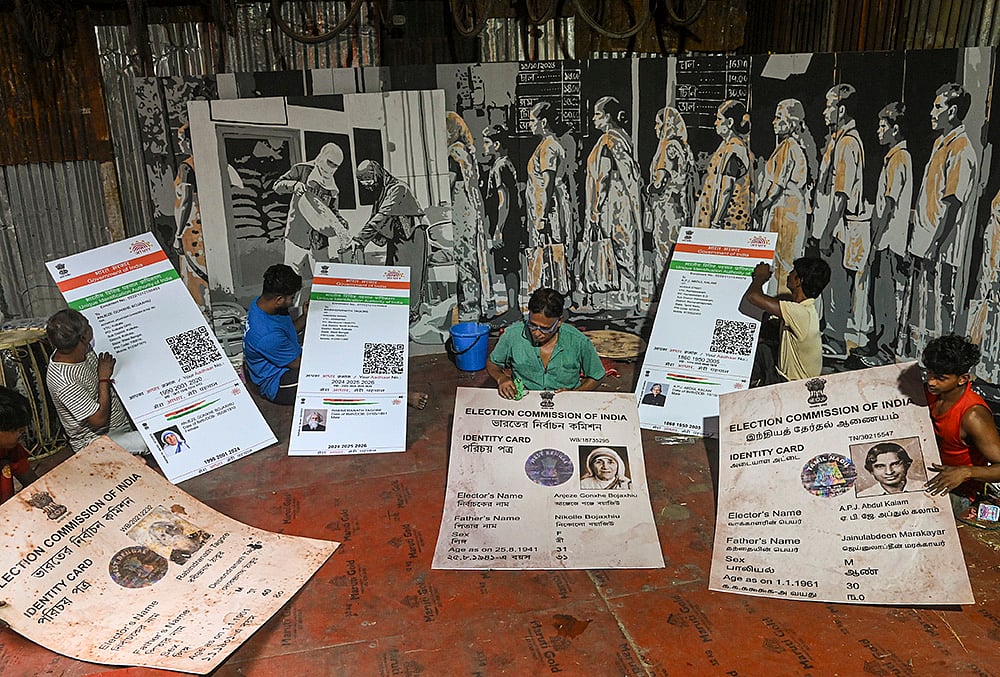 Artists and club members finish installation of giant replicas of Aadhar and voter identity cards of legendary poet Rabindranath Tagore, former president and scientist APJ Abdul Kalam and Mother Teresa, amid preparations for the 'Durga Puja' festival, at 'Humanity' themed Khidirpur Jubak Sangha community pandal, in Kolkata, West Bengal.
 - | Photo: PTI 