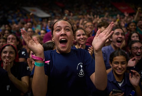 Members of Castellers Xiquets del Serrallo react as another team forms a "castell" human tower during the 30th Concurs de Castells, or Human Tower Competition, in Tarragona, Spain, Saturday, Oct. 5, 2026. 
