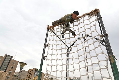 A member of the Iranian army performs a training exercise during the opening ceremony of one of the military training centers for volunteers being set up throughout squares in downtown Tehran, Iran, Saturday, Oct. 3, 2026. 
