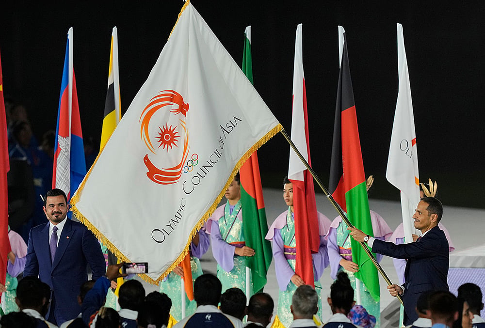 President of the Olympic Council of Asia, Sheikh Joaan Bin Hamad Al Thani, left, looks at the Olympic Council of Asia flag as the as Sheikh Mohammed bin Abdulrahman Al Thani, Prime Minister of Qatar holds it during the closing ceremony for the Asian Games in Nagoya, Japan, Sunday, Oct. 4, 2026.  - | Photo: AP/Dita Alangkara