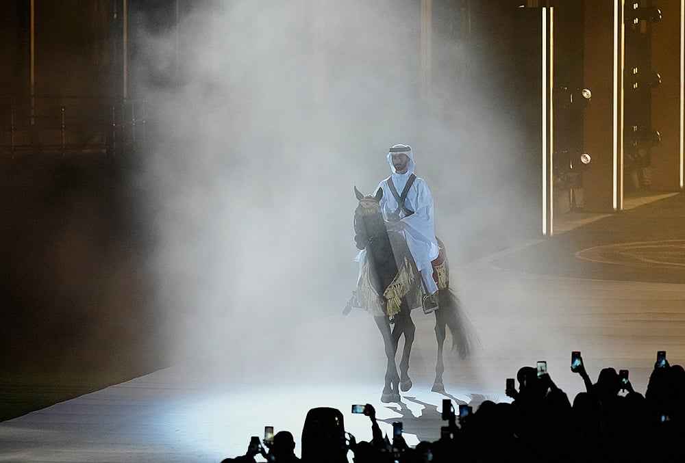 Qatar equestrian athlete Jassim Al Kuwari holds the Olympic Council of Asia flag
