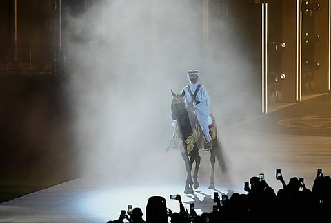 Qatar equestrian athlete Jassim Al Kuwari holds the Olympic Council of Asia flag during the closing ceremony for the Asian Games in Nagoya, Japan, Sunday, Oct. 4, 2026.