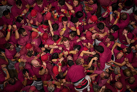 Members of Castellers de Lleida react after completing a "castell" human tower during the 30th Concurs de Castells, or Human Tower Competition, in Tarragona, Spain, Saturday, Oct. 5, 2026. 
