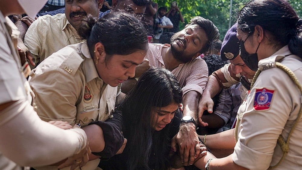 Police personnel detain people protesting against the CEC near the Jantar Mantar, in New Delhi
 - | Photo: PTI/Karma Bhutia