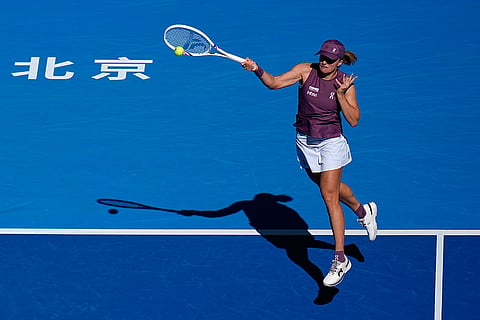 Iga Swiatek, of Poland, returns a ball to Donna Vekic, of Croatia, during the third round of the women's singles match at the China Open tennis tournament in Beijing, Monday, Oct. 5, 2026.