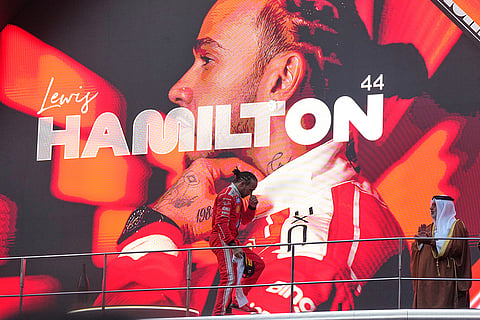 Ferrari driver Lewis Hamilton of Britain steps on the podium after arriving in third place at the Bahrain Grand Prix in Sepang, Malaysia, Sunday, Oct. 4, 2026.