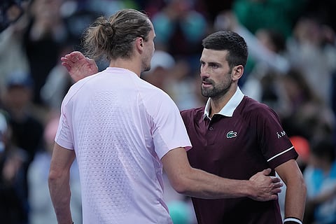 Novak Djokovic, of Serbia, is greeted by Alexander Zverev, of Germany, after winning in the men's singles quarterfinals match at the China Open tennis tournament in Beijing, Sunday, Oct. 4, 2026.