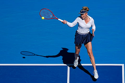 Donna Vekic, of Croatia, returns a ball to Iga Swiatek, of Poland, during the third round of the women's singles match at the China Open tennis tournament in Beijing, Monday, Oct. 5, 2026.