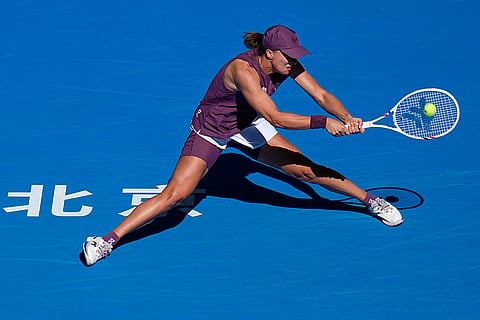 Iga Swiatek, of Poland, returns a ball to Donna Vekic, of Croatia, during the third round of the women's singles match at the China Open tennis tournament in Beijing, Monday, Oct. 5, 2026.