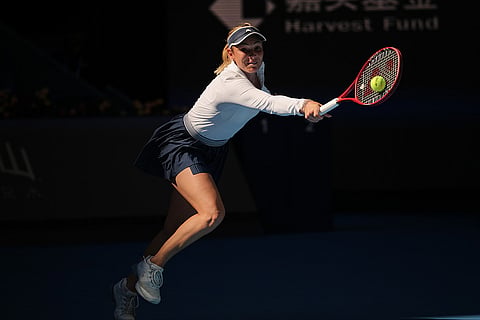Donna Vekic, of Croatia, returns a ball to Iga Swiatek, of Poland, during the third round of the women's singles match at the China Open tennis tournament in Beijing, Monday, Oct. 5, 2026.