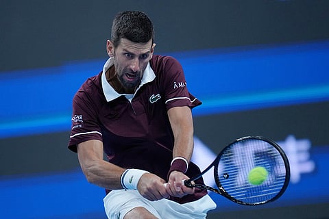 Novak Djokovic, of Serbia, returns a ball to Alexander Zverev, of Germany, during the men's singles quarterfinals match at the China Open tennis tournament in Beijing, Sunday, Oct. 4, 2026.
