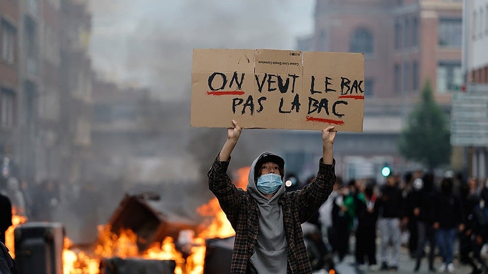 A students holds a board reading, "we want the BAC (High School Diploma) Not the BAC (Anti-criminality units)" during a protest to demand more resources at school, in Lille, France.
 - | Photo: AP/Jean-Francois Badias