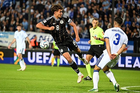 Germany's Tom Bischof, centre, and Greece's Dimitrios Kourbelis challenge for the ball during the UEFA Nations League soccer match between Greece and Germany in Thessaloniki, northern Greece, Sunday, Oct. 4, 2026.