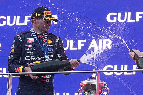 Red Bull driver Max Verstappen of the Netherlands sprays rose water on the podium after winning the Bahrain Grand Prix in Sepang, Malaysia, Sunday, Oct. 4, 2026.