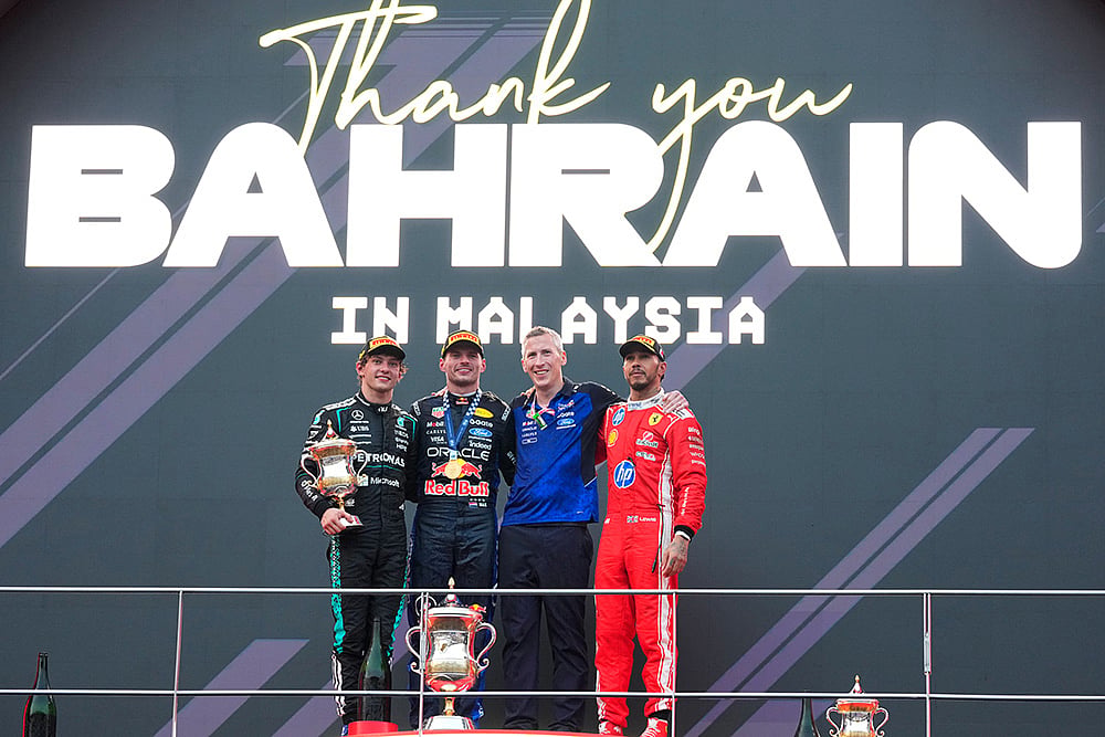 Red Bull driver Max Verstappen of the Netherlands celebrates on the podium flanked by second place Mercedes driver Andrea Kimi Antonelli of Italy, left and third place Ferrari driver Lewis Hamilton of Britain after winning the Bahrain Grand Prix in Sepang, Malaysia, Sunday, Oct. 4, 2026. - | Photo: AP/Vincent Thian
