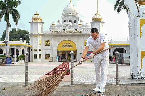 Uttarakhand Chief Minister Pushkar Singh Dhami sweeps the ground with a broom during a cleanliness drive at Gurudwara Nanakmatta Sahib, in Udham Singh Nagar district.