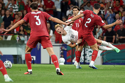 Norway's Andreas Schjelderup falls to the ground in a clash with Portugal's Diogo Dalot, right, during the Nations League soccer match between Portugal and Norway in Porto, Portugal, Sunday, Oct. 4, 2026.