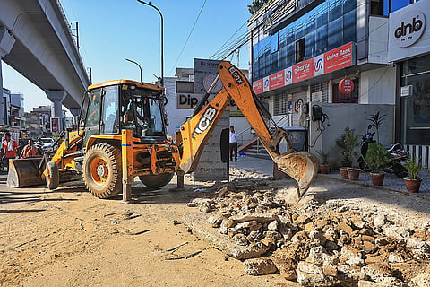An excavator demolishes illegal structures during an anti-encroachment drive carried out by authorities on New Sanganer Road, in Jaipur, Rajasthan. The drive follows Rajasthan High Court directives to clear illegal encroachments affecting around 260 shops and houses to widen the road corridor.