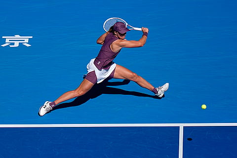 Iga Swiatek, of Poland, returns a ball to Donna Vekic, of Croatia, during the third round of the women's singles match at the China Open tennis tournament in Beijing, Monday, Oct. 5, 2026.