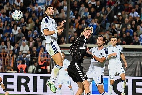 Greece's Konstantinos Koulierakis, top, heads the ball during the UEFA Nations League soccer match between Greece and Germany in Thessaloniki, northern Greece, Sunday, Oct. 4, 2026.
