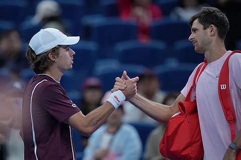 Hubert Hurkacz of Poland, right, shakes hands with Alex De Minaur, of Australia, after he retired from the men's single semi-final match at the China Open tennis tournament in Beijing, Monday, Oct. 5, 2026.
