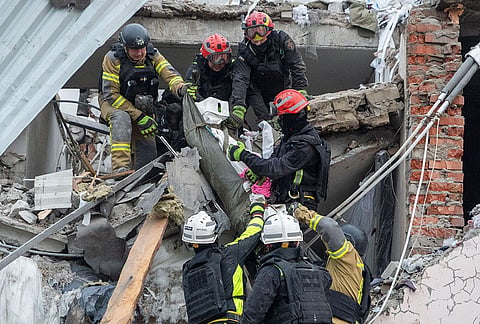 Rescue workers carry a body from an auto repair shop damaged by a Russian strike on Kharkiv, Ukraine, Monday, Oct. 5, 2026. 