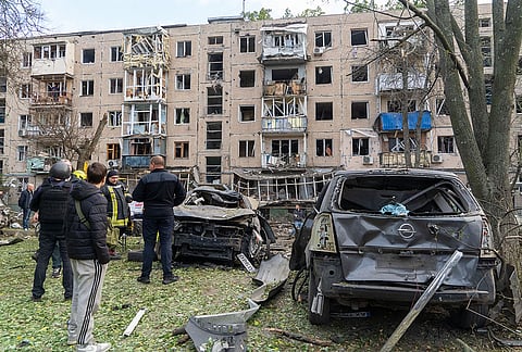 People look at a residential house damaged by a Russian strike on Kharkiv, Ukraine, Monday, Oct. 5, 2026. 
