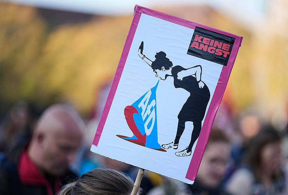 A woman holds a poster reading: "No Fear" as she attends a protest against the far-right AfD, Alternative for Germany, party Prior to the constituent session of the new elected German federal state parliament of Saxony-Anhalt in Magdeburg, Germany, Tuesday, Oct. 6, 2026. Poster reads: No cooperation with the far right. 
 - | Photo: AP/Matthias Schrader