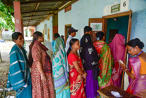 Voters stand in a queue to cast their votes for the Nagaon Lok Sabha by-poll, at a polling station in Buraburi, Morigaon district, Assam.