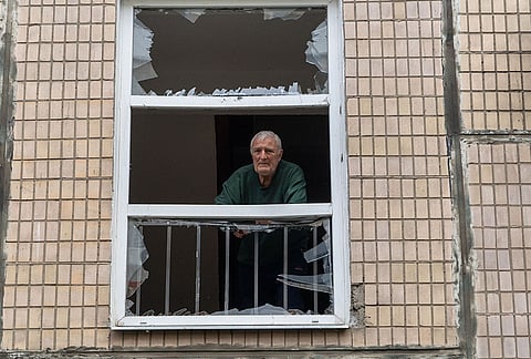 A man looks through a broken window in a residential house damaged by a Russian strike on Kharkiv, Ukraine, Monday, Oct. 5, 2026. 
